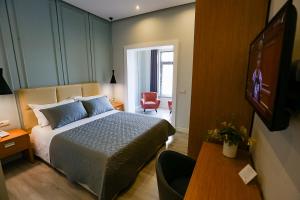 1 dormitorio con 1 cama, 1 mesa y 1 silla en Home Hotel en Tirana