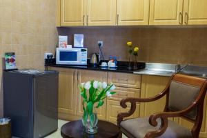 a kitchen with a vase of flowers on a table at Kingsgate Hotel Doha by Millennium Hotels in Doha