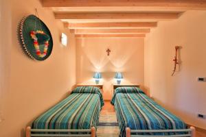 two beds in a room with a cross on the wall at Madonie Park Gates - Casa in C.Da Donalegge in Castellana Sicula
