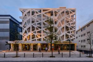 a building with people walking in front of it at Hotel Regina in Fátima