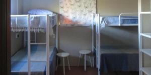 a room with three bunk beds and two stools at Donkerhoek Country Living in Avondzon