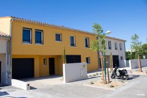 un edificio amarillo con dos motocicletas estacionadas frente a él en BASTIDE 7 en La Fare-les-Oliviers