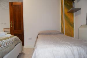 - une chambre avec 2 lits et une porte en bois dans l'établissement B&B La terrazza, à Montalbano Elicona