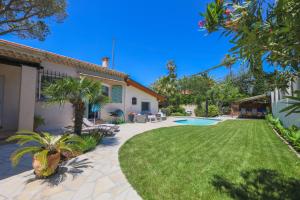 a house with a yard with a swimming pool at VILLA LES ONDES VI4120 in Juan-les-Pins
