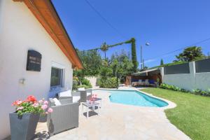 a backyard with a swimming pool and a house at VILLA LES ONDES VI4120 in Juan-les-Pins