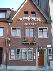 a brick building with a sign for a guesthouse district at Guesthouse Dusart in Hasselt