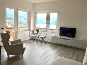 un soggiorno con TV e tavolo con sedie di Appartamento tra lago e cielo a Como
