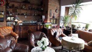 salon ze skórzanymi krzesłami i barem w obiekcie Kwatery Prywatne Hotelik w mieście Barczewo
