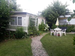 stół i krzesła na dziedzińcu przyczepy kempingowej w obiekcie Kwatery Prywatne Hotelik w mieście Barczewo