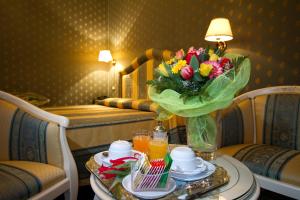 ein Hotelzimmer mit einem Tisch mit einer Blumenvase in der Unterkunft Hotel Conterie in Murano