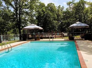 a large swimming pool with two umbrellas next to it at Mill Creek Resort on Table Rock Lake in Lampe