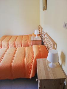 a bedroom with two beds with orange sheets and lamps at Casa Ester in Castelpetroso
