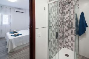 W łazience znajduje się przeszklony prysznic z łóżkiem. w obiekcie WintowinRentals All Comforts Málaga Center w Maladze
