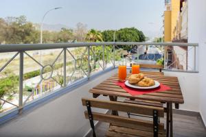 stół z talerzem jedzenia na balkonie w obiekcie WintowinRentals All Comforts Málaga Center w Maladze