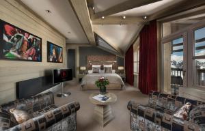 a bedroom with a bed and a tv and couches at Le K2 Djola in Courchevel