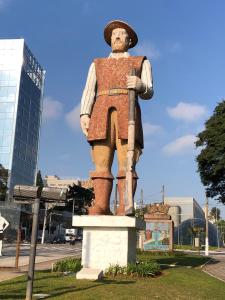 Una statua di un uomo in piedi su un piedistallo di Hostel Borba Gato a San Paolo