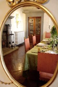 a dining room with a table in a mirror at Villa Vistarenni in Gaiole in Chianti