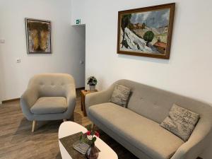 ein Wohnzimmer mit einem Sofa und einem Stuhl in der Unterkunft Hotel und Apartment Garni Eurode Live in Herzogenrath