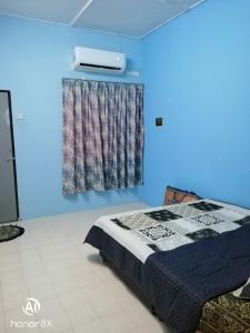 a blue room with a bed and a window at BB HOMESTAY in Kampung Tualang