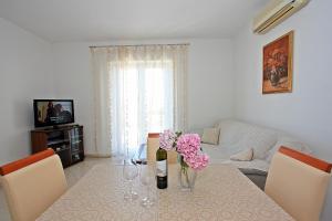 un soggiorno con tavolo e fiori di Apartment Igor a Supetar (San Pietro di Brazza)