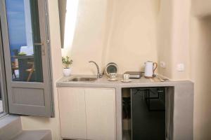 a bathroom with a sink and a mirror at Santorini Villas in Vourvoulos