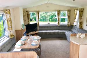 a living room with a couch and a table at Mersea Island by Away Resorts in Colchester