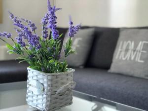 a white vase with purple flowers on a table at Apartments Villa Anna Sonia in Podstrana +18 photos