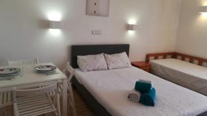 a small room with two beds and a table with a scale at Praia da Rocha Apartment 3 in Portimão