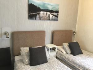 uma sala de estar com duas camas e um quadro na parede em Kirkstall Guest House em Blackpool