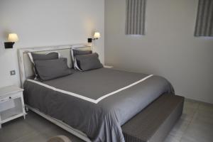 a bedroom with a large bed with gray pillows at Luxury Villa at Royal Park Sandpiper in La Bergerie