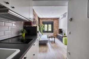eine Küche und ein Wohnzimmer mit einer Ziegelwand in der Unterkunft Ever House - ALCALA CIELO 1 ROOFTOP in Madrid