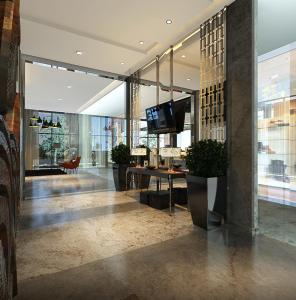 a lobby with a desk and a television in a building at Neo Hotel Mangga Dua by ASTON in Jakarta