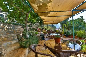 a patio with tables and chairs under a wooden umbrella at Hamarat Otel in Kaş