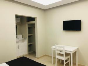 um quarto com uma mesa e uma televisão na parede em HOTEL VICTORIA em Ciudad Constitución