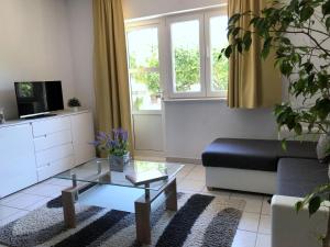 een woonkamer met een bank en een salontafel bij Apartments Villa Anna Sonia in Podstrana