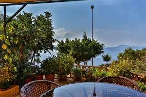 a table and chairs with a view of the ocean at Hamarat Otel in Kaş