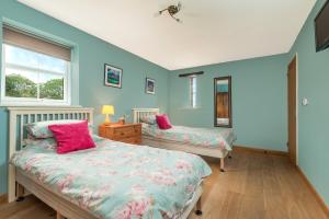 una camera da letto con due letti e una finestra di Kidwelly Farm Cottage a Kidwelly Altre 22 foto