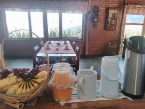 a table with a bunch of bananas and a basket of fruit at Reobote Chalés in São Bento do Sapucaí