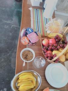 a wooden table topped with bowls of fruit and nuts at Reobote Chalés in São Bento do Sapucaí