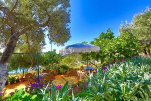 a patio with an umbrella and chairs and flowers at Hamarat Otel in Kaş