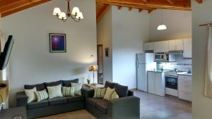 Il comprend un salon avec un canapé et une cuisine. dans l'établissement Búngalows Osa Mayor, à Villa La Angostura