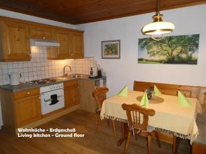 a kitchen with a table with two chairs and a sink at Gästehaus am Weinberg - Schlager in Prinzersdorf