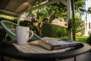 un libro y una taza y un teclado sobre una mesa en Apartments Medora, en Rovinj