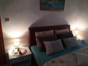 1 dormitorio con 1 cama con almohadas y 2 lámparas en Apartments Villa Andjela, en Budva