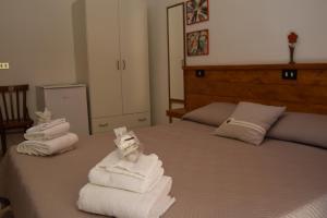 1 dormitorio con 1 cama con toallas plegables. en B&B Casa di Mamma, en Corato