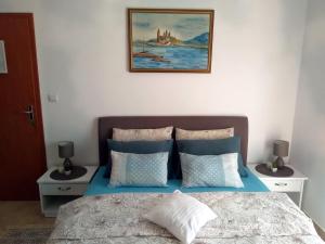 um quarto com uma cama com uma fotografia na parede em Apartments Villa Andjela em Budva