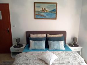 a bedroom with a bed with a picture on the wall at Apartments Villa Andjela in Budva