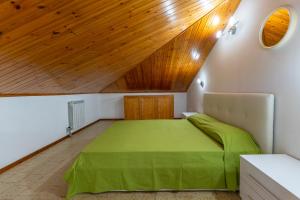 リド・デッリ・エステンシにあるApartment Ampioの木製の天井が特徴のベッドルーム1室(緑のベッド1台付)