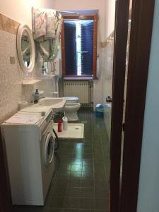ein Badezimmer mit einer Waschmaschine und einem WC in der Unterkunft Villa Roma in Alfedena