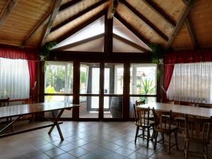 a dining room with two tables and chairs and windows at T.S.G. Šimanović in Klinča Sela
